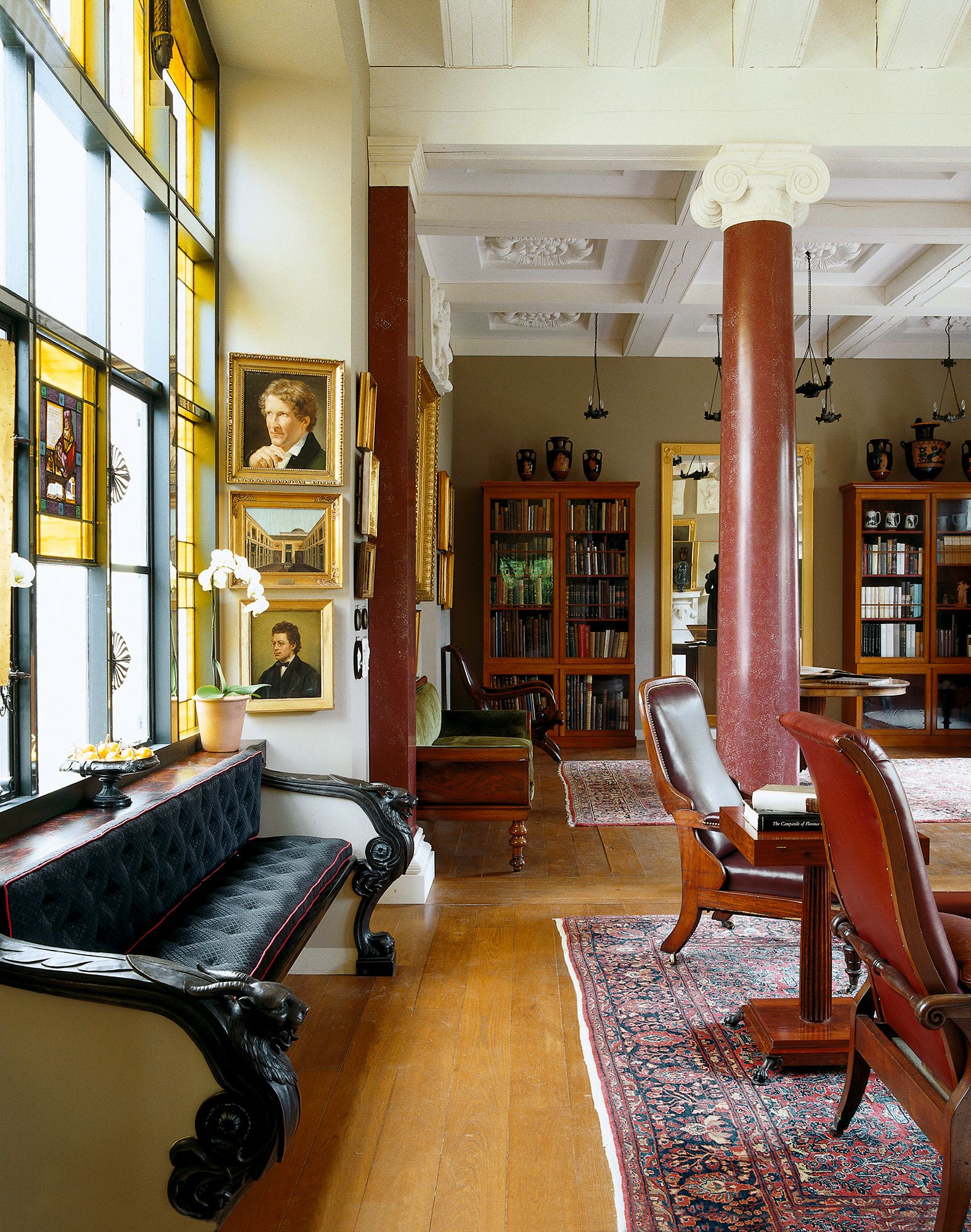 Image may contain Furniture Living Room Room Indoors Couch Flooring Human Person Wood Hardwood and Chair