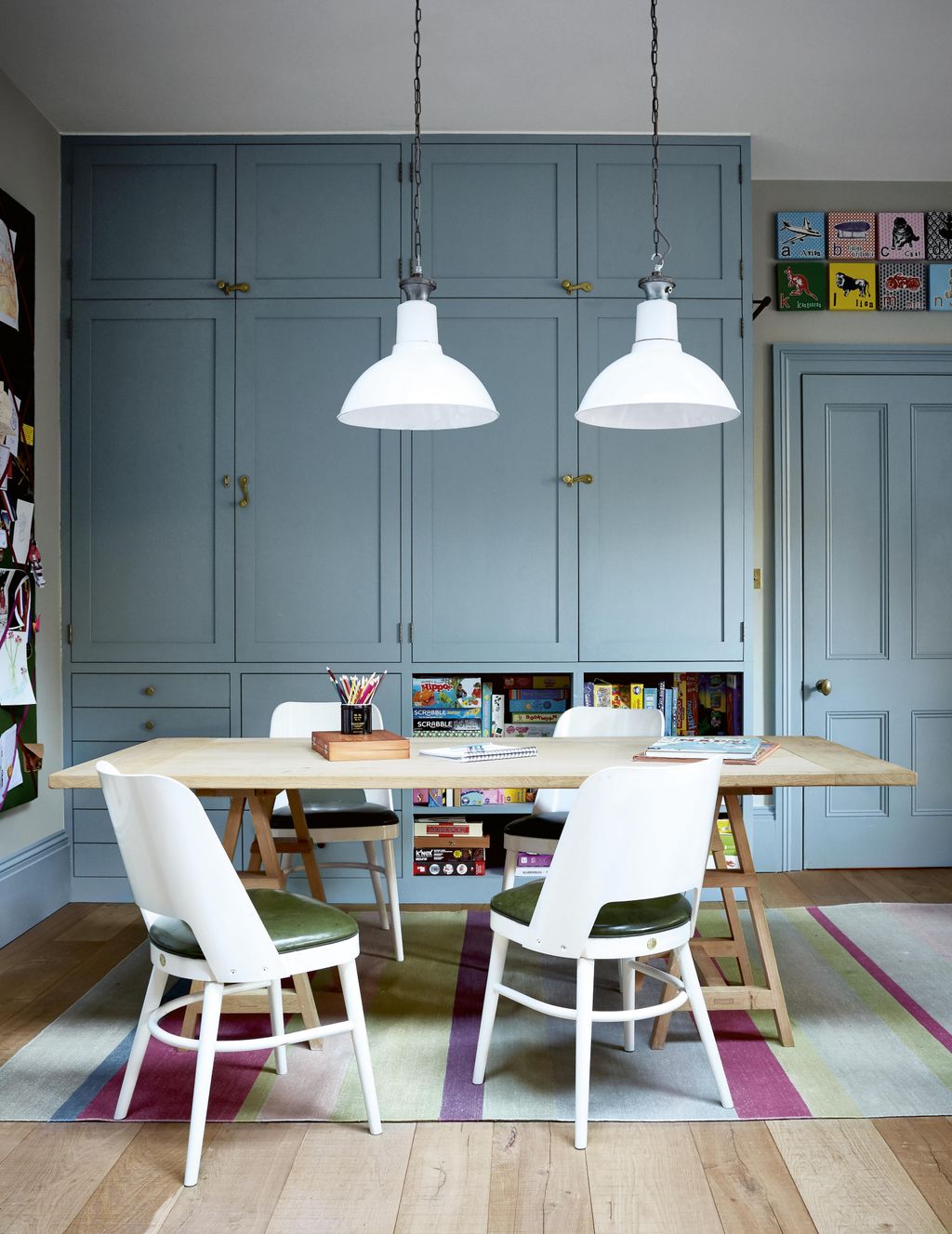 The wooden crafting table was made by Matthew Cox. Two Vanderhurd rugs help to define the different areas.