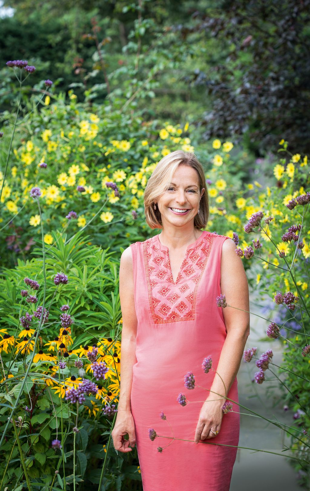 Image may contain Dress Clothing Apparel Human Person Outdoors Plant Garden Face Flower Blossom and Vegetation