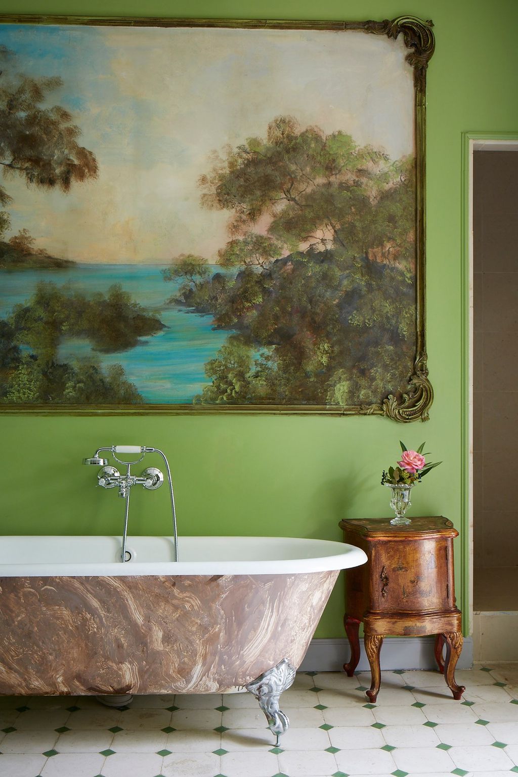 In this bathroom a large painting hangs against green walls which highlight the green details on the tiled floor.  Like...