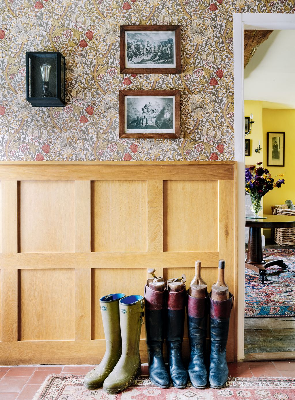 ‘Golden Lily wallpaper by Morris Co and new oak panelling line the walls with original quarry tiling on the floor.