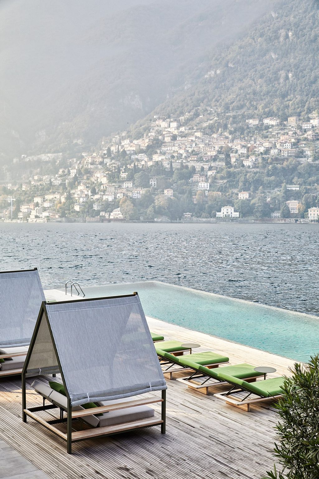 At the water's edge there are rows of deck chairs and beds made in a combination of modern and traditional materials.