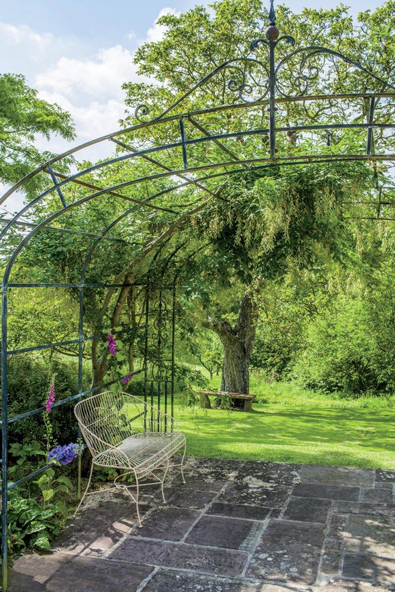 Image may contain Outdoors Garden Porch Furniture Arbour Patio Bench and Plant