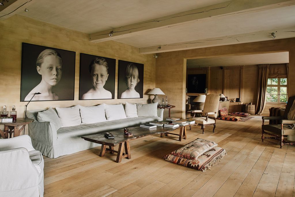 Image may contain Flooring Human Person Wood Furniture Couch Living Room Room Indoors Hardwood Floor and Table