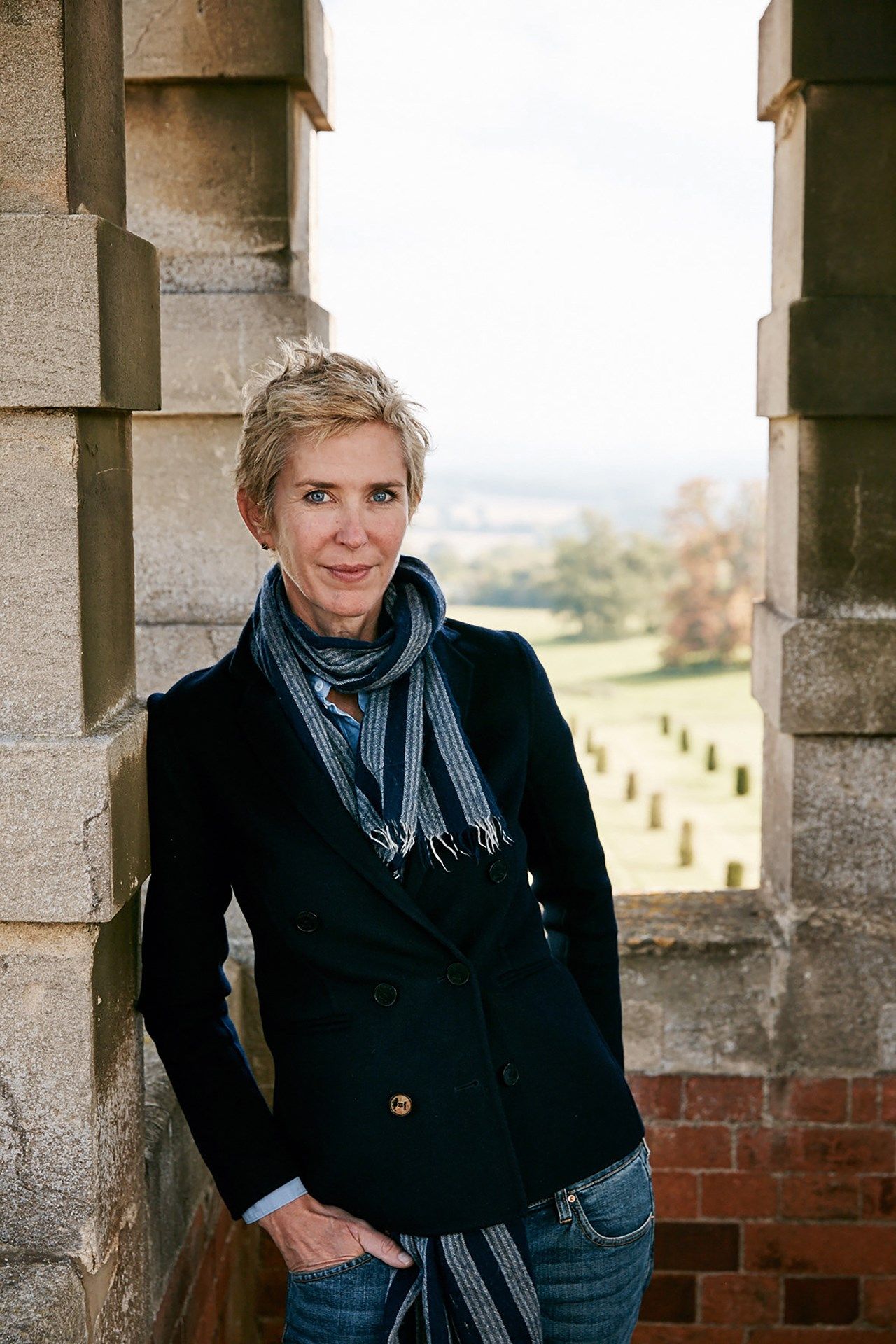 Image may contain Clothing Apparel Overcoat Coat Suit Human Person Tuxedo and Scarf