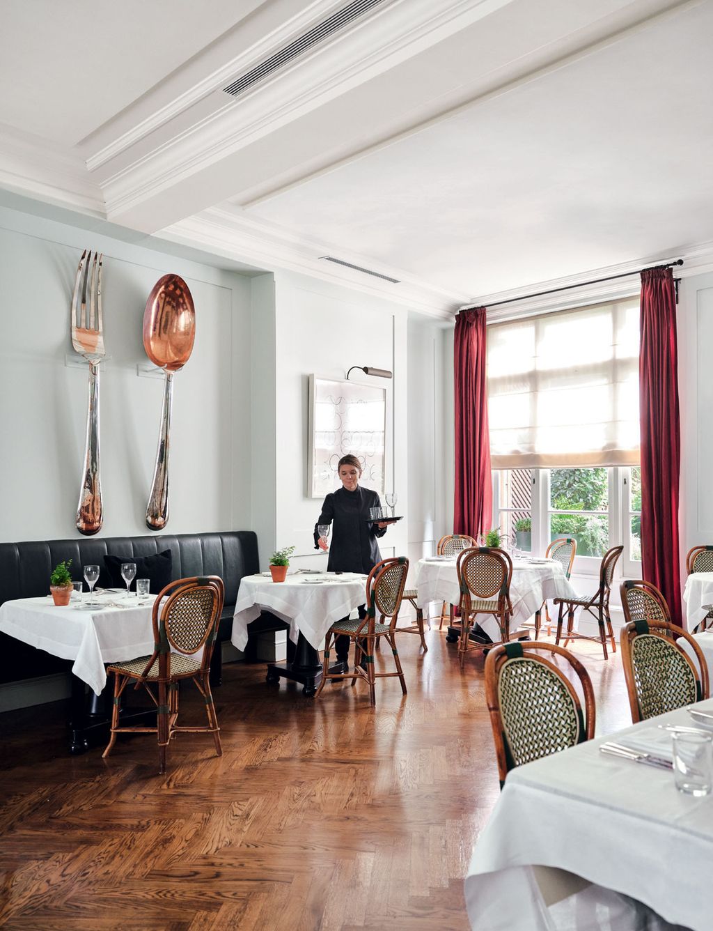 An oversized cutlery artwork is displayed at one end of the restaurant.