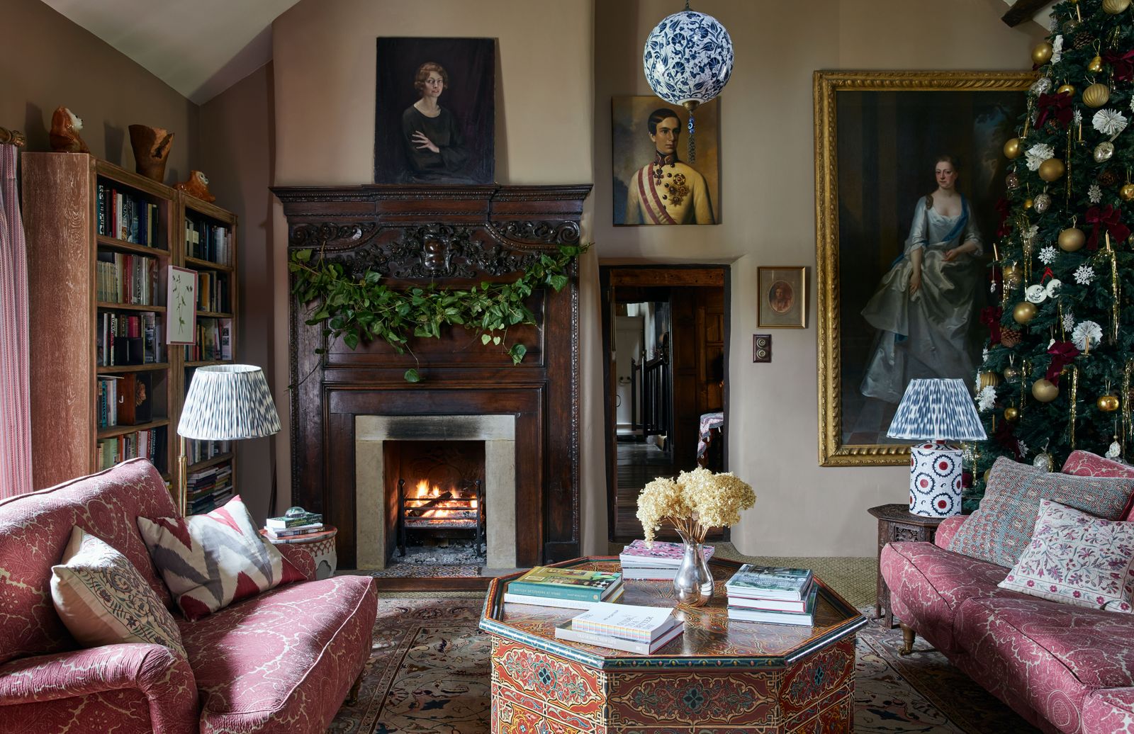 Walls in ‘Chocolate by Edward Bulmer Natural Paint provide a muted backdrop for a mixture of portraits. Two sofas...