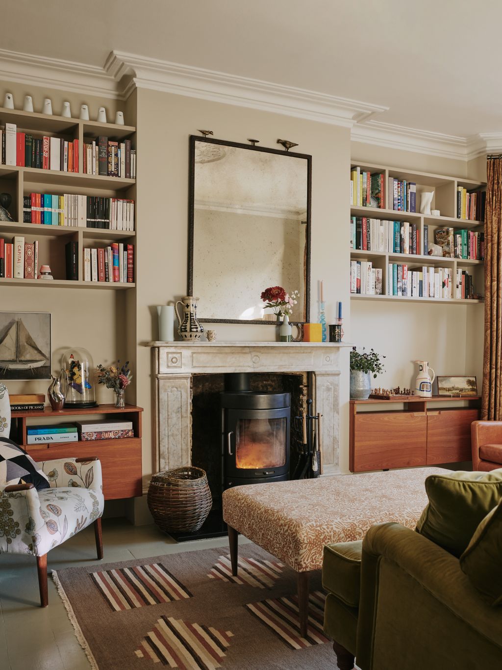 Image may contain Furniture Living Room Room Indoors Interior Design Couch Fireplace Bookcase Hearth Shelf and Rug