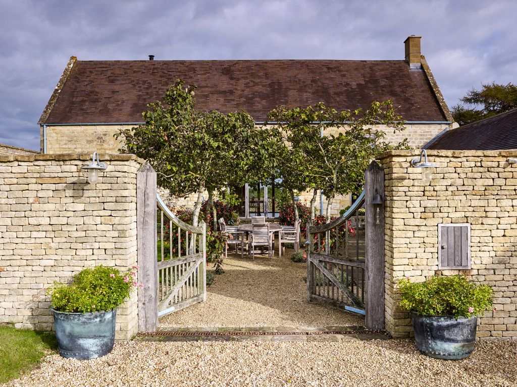 Image may contain Outdoors Gate Gravel Road Dirt Road Garden Arbour Vase Plant Pottery Potted Plant and Jar