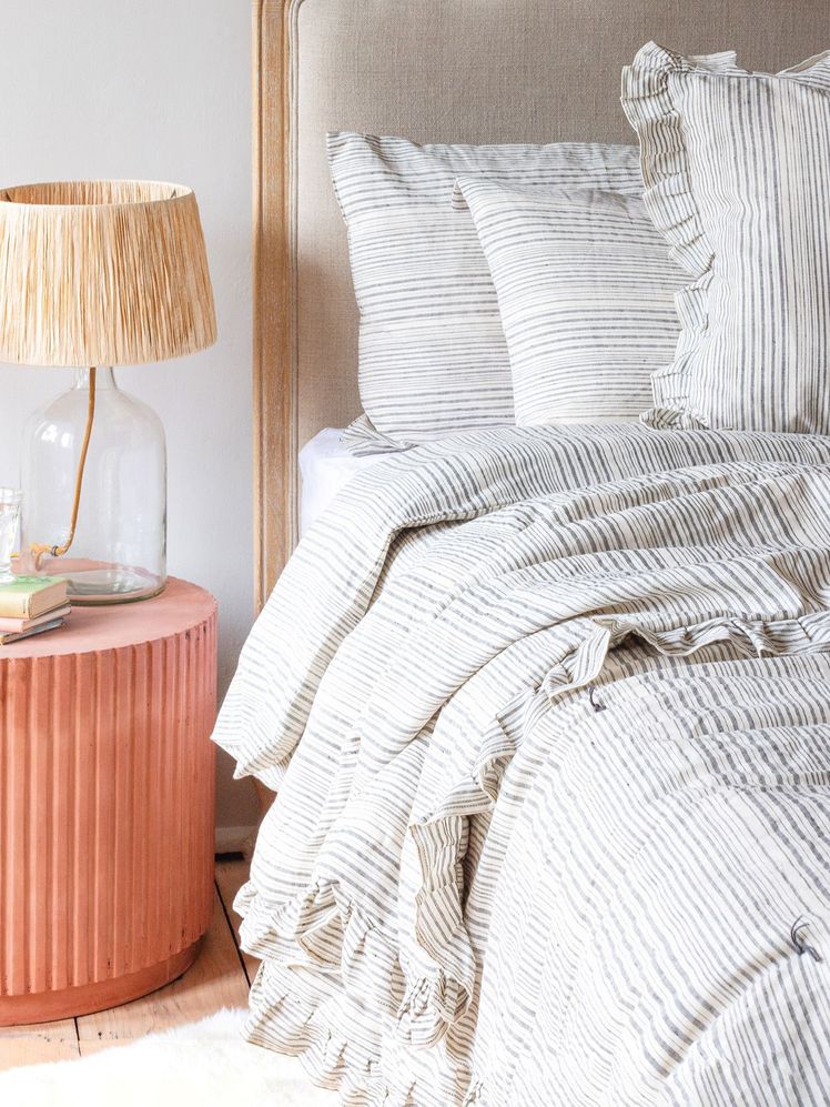 Image may contain: Cushion, Pillow, Indoors, Room, Bedroom, Home Decor, Lamp, and Table Lamp