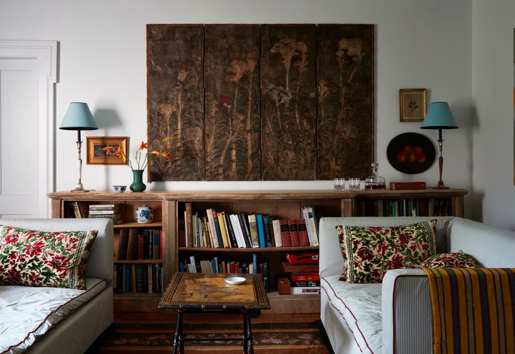 Image may contain Furniture Couch Living Room Indoors Room Bookcase Shelf Interior Design Lamp and Table Lamp