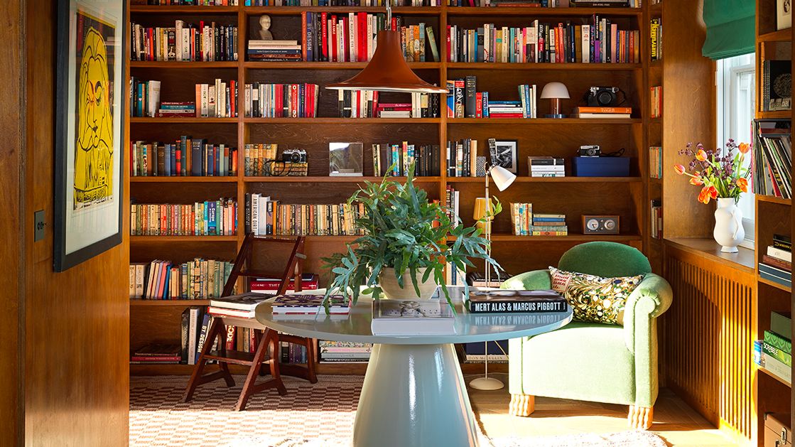 Image may contain Furniture Bookcase Shelf Indoors Room Library Book Living Room Wood and Rug