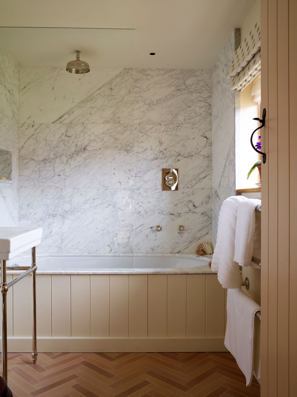 The tiles are ‘Birch Herringbone by Otto Tiles. The marble is Carrara marble.