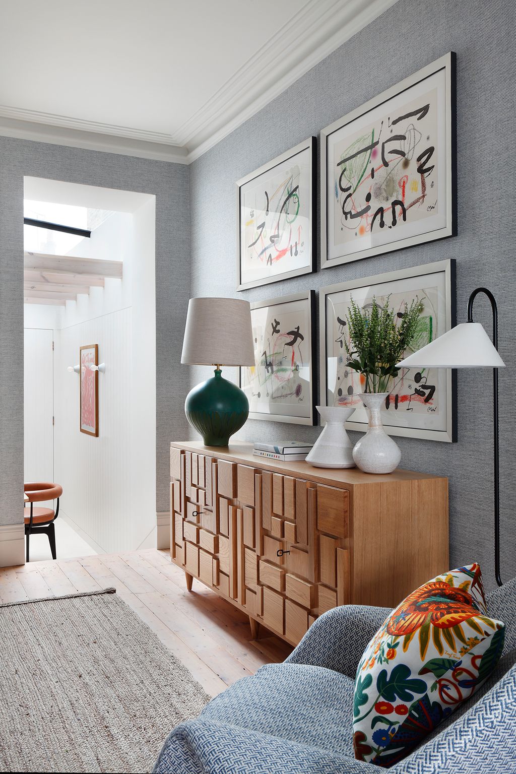 Iva Polachova vases from WSJ Gallery sit atop a custom Fiona McDonald cabinet. The large ceramic lamp is from Visual...