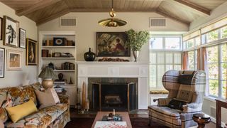 Image may contain Fireplace Indoors Living Room Room Interior Design Furniture Home Decor Hearth Flooring and Human