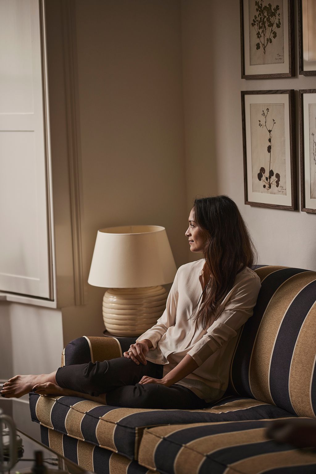 Image may contain Lamp Table Lamp Human Person Couch and Furniture