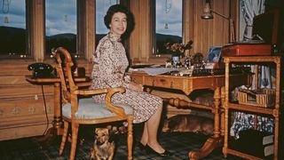 Image may contain Furniture Chair Human Person Elizabeth II Wood Flooring Table Screen Electronics and Monitor