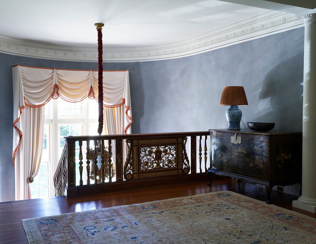 Image may contain Flooring Floor Hardwood Wood Interior Design Indoors Banister Handrail Living Room Room and Lamp