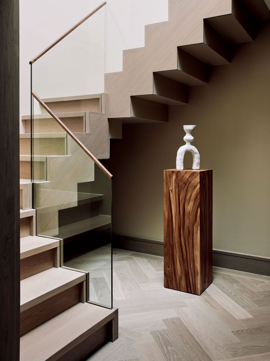 A white stoneware sculpture by Noe Kuremoto is displayed on a chamcha wood pedestal from Phillips Collection.