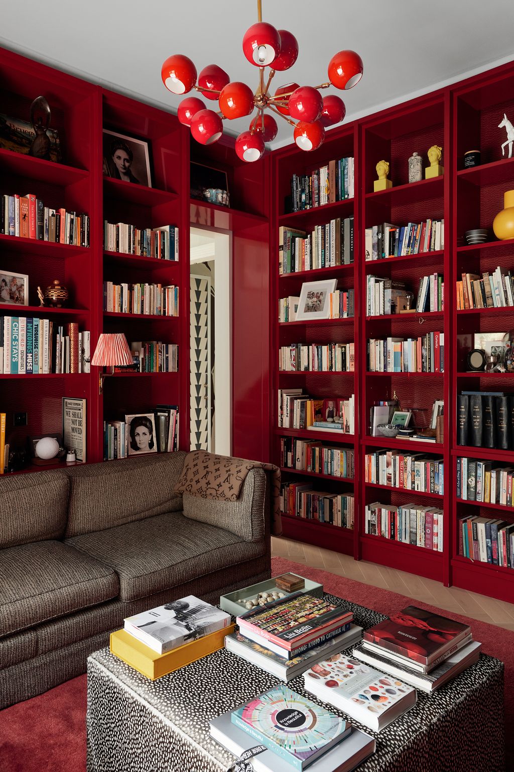 Image may contain Furniture Bookcase Shelf Indoors Room Living Room Couch Interior Design Library and Book