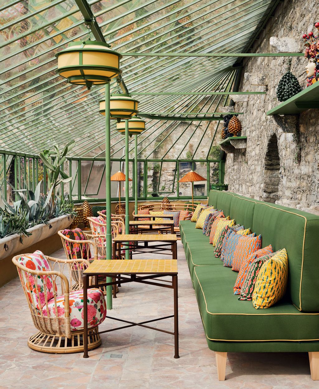 The Winter Garden orangery next to the pool is furnished with colourful cushions and matching tableware from Milanese...