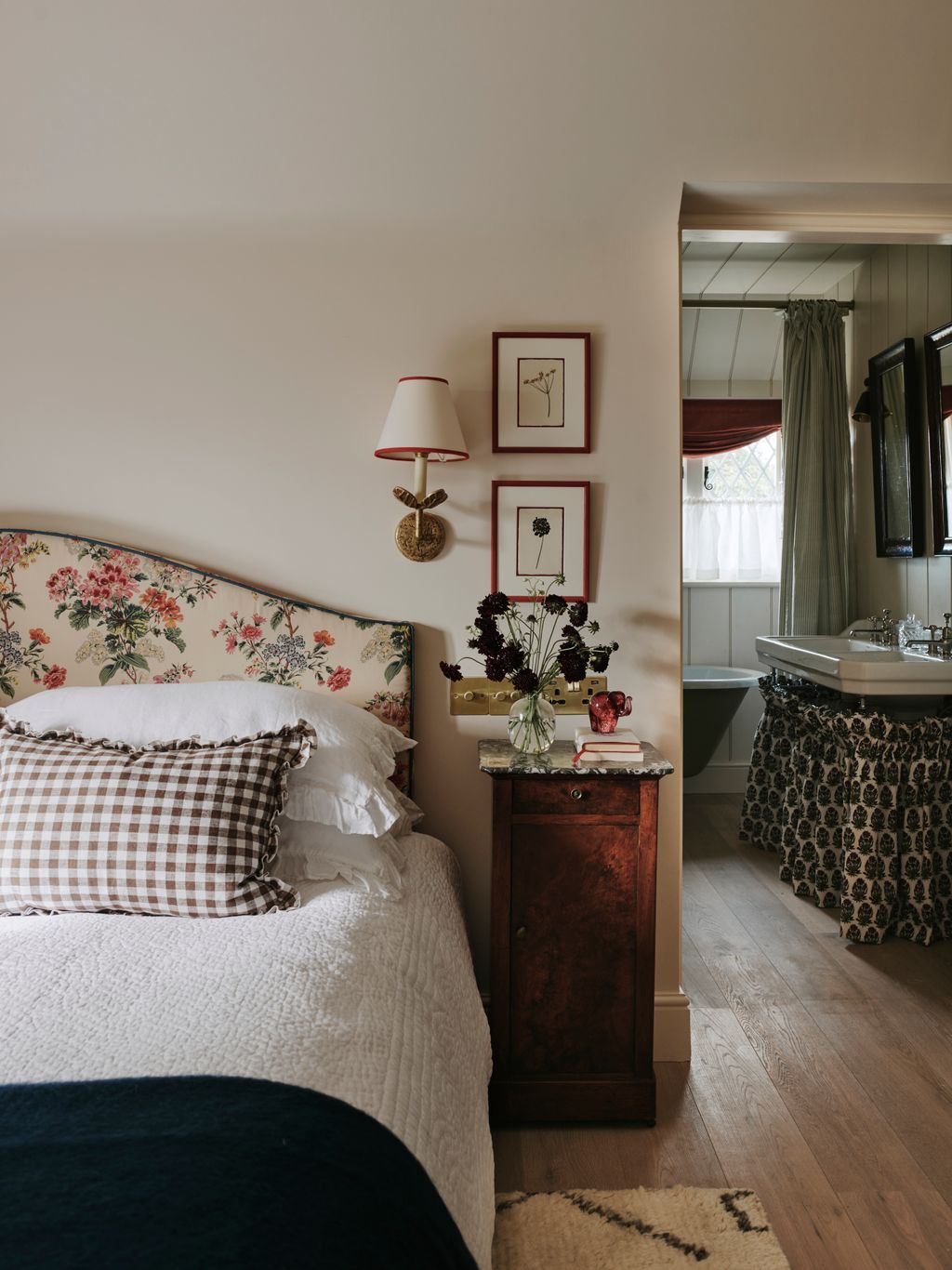 In the master bedroom walls painted in Farrow  Ball's ‘Dimity provide a muted backdrop for a headboard upholstered in Le...