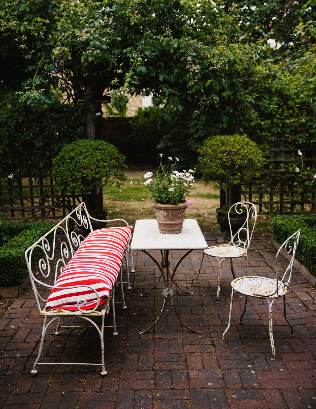 On the terrace in the garden the marbletop table is from Puckhaber Antiques and the Georgian bench was found at Henley...