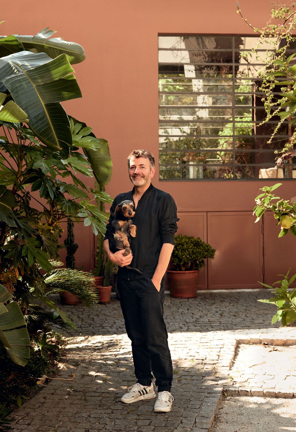 Image may contain Clothing Shoe Footwear Apparel Human Person Arbour Garden Outdoors Flagstone Plant and Vase