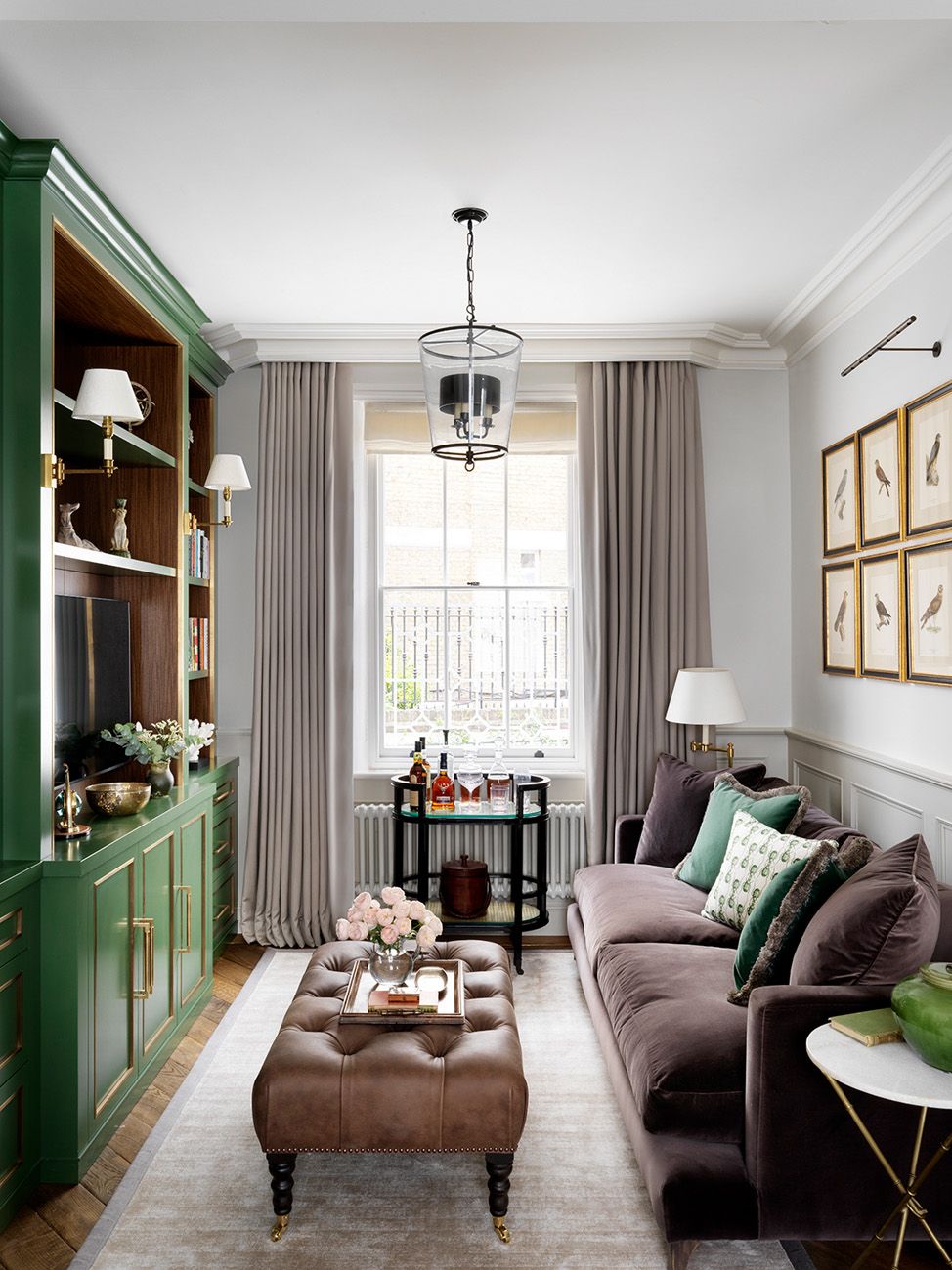 The joinery surrounding the television was bespoke by Sims Hilditch painted in Farrow  Balls ‘Minster Green. The sofa is...
