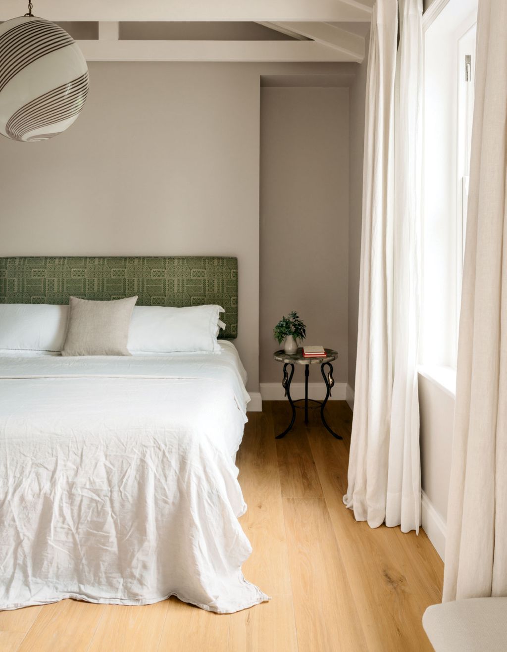 A headboard in Lewis  Woods ‘Batik in peridot a Venini Murano light from 1stDibs and a table from Robin Myerscough...