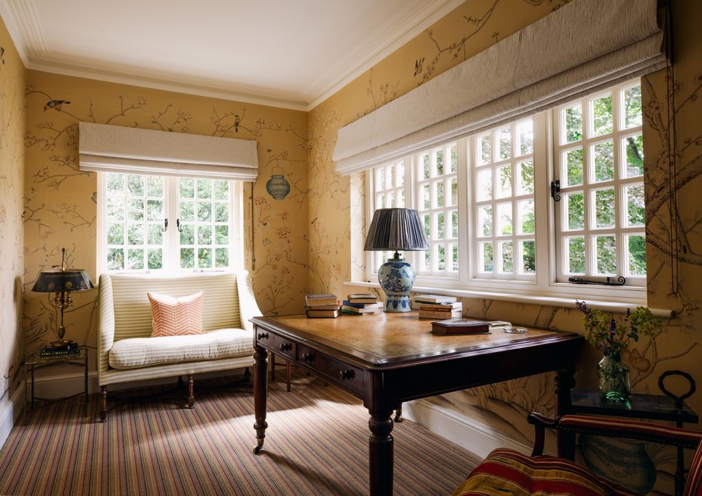 On the landing De Gournay wallpaper lines the walls whilst a Lorfords sofa provides a place of respite.