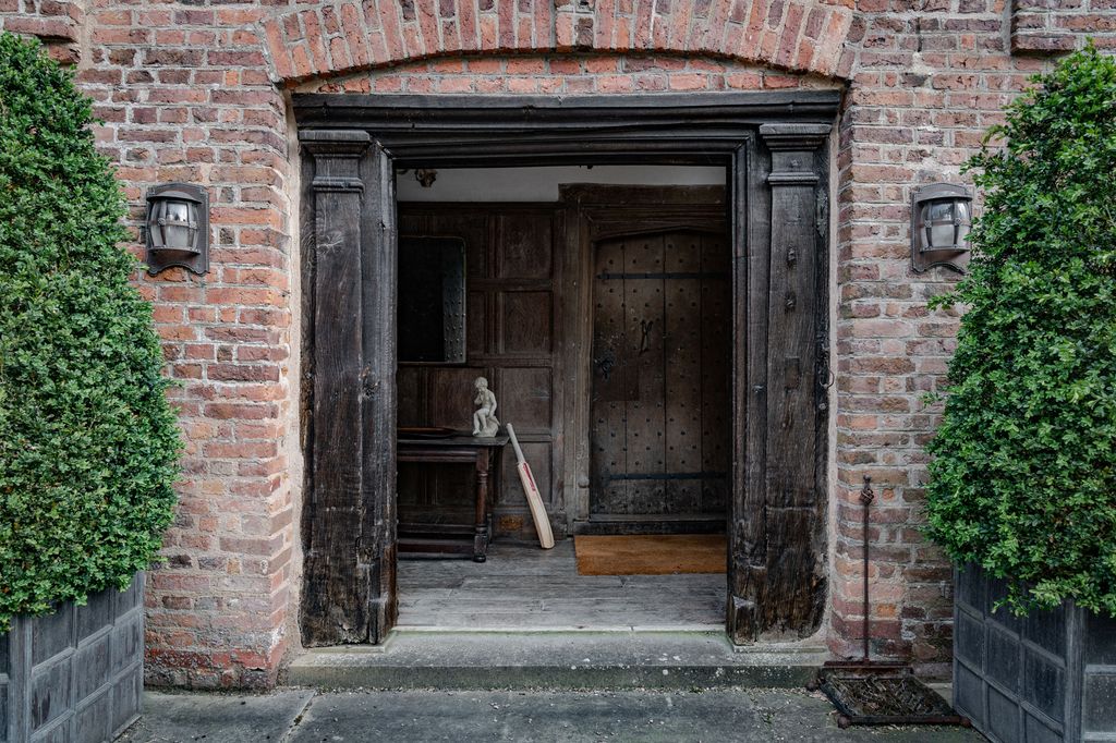 A stout planked door opens into a small hall wainscoted in oak from the nearby woods. The doors are densely studded for...