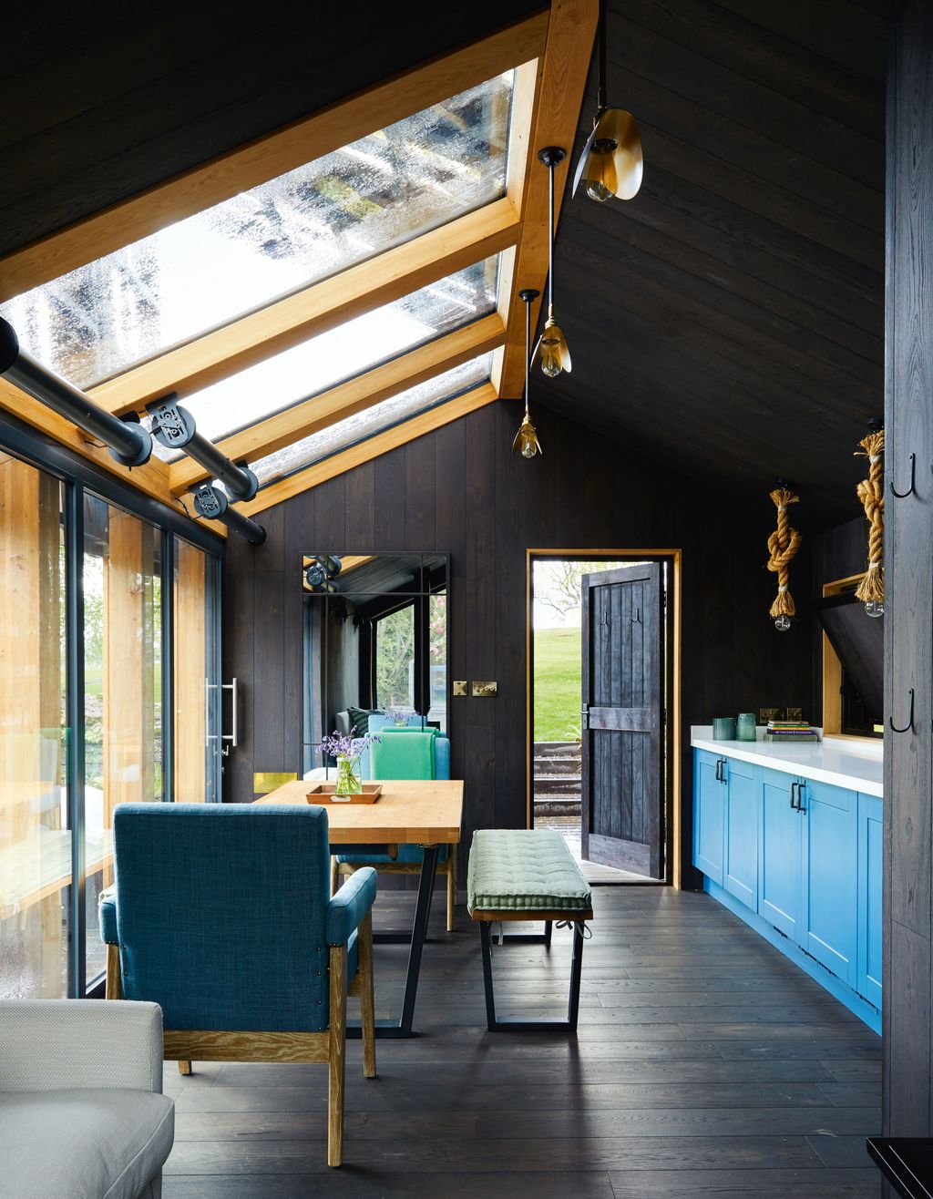 John Lewiss ‘Calia dining table and bench and Julian Chichester archive ‘N chairs in a blue Mark Alexander fabric stand...