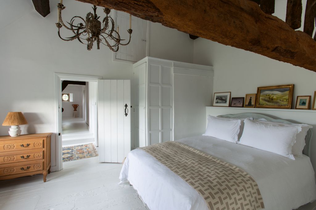 Four coats of Little Greene's ‘Loft White cover the floorboards in the guest bedroom. The light fixture is a vintage...