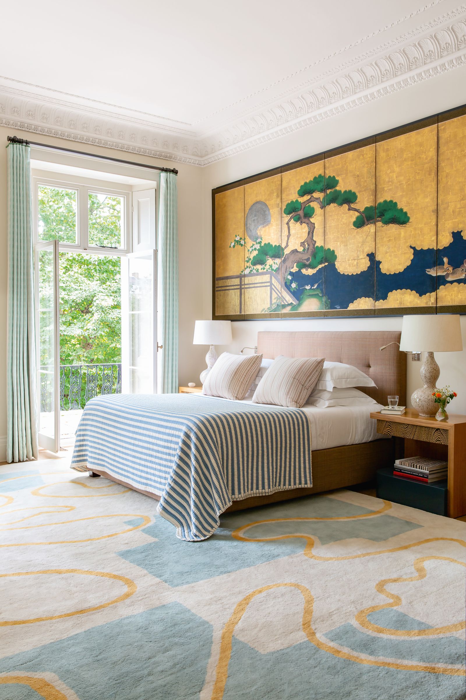 An 18thcentury Japanese paper screen from Gregg Baker hangs above the bed and bedside tables which are paired with Penny...