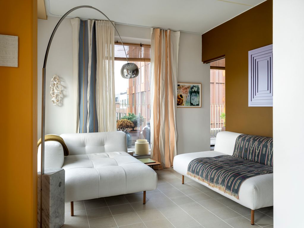 The main living area featuring De Padova Eres sofas Flos Arco lamp collage by Karl Monies wall sculpture by Inger...