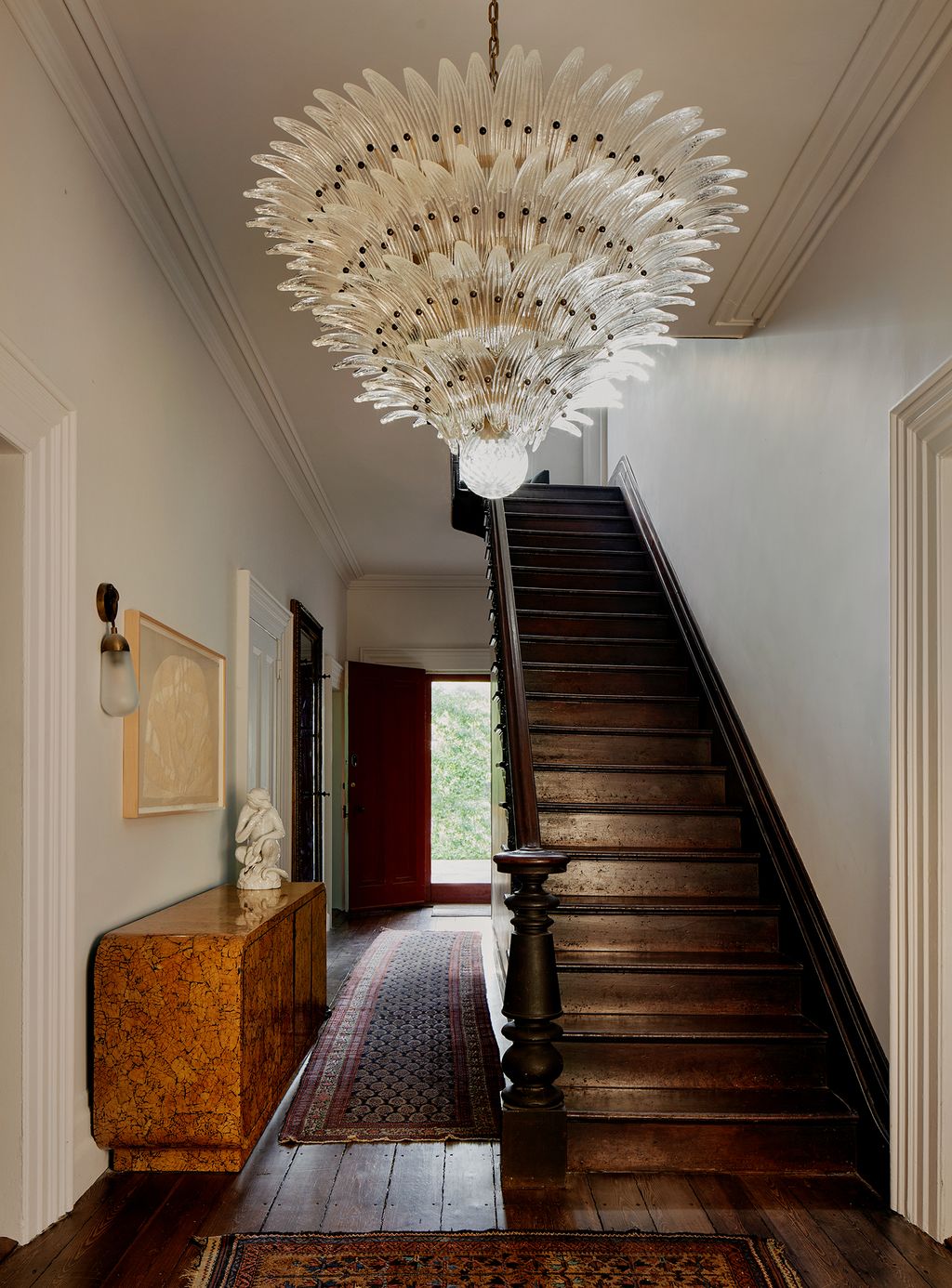 The entryway of the home has a 1970s rounded edgenbspPace credenza hugging the hallway. A vintage Persian carpet...