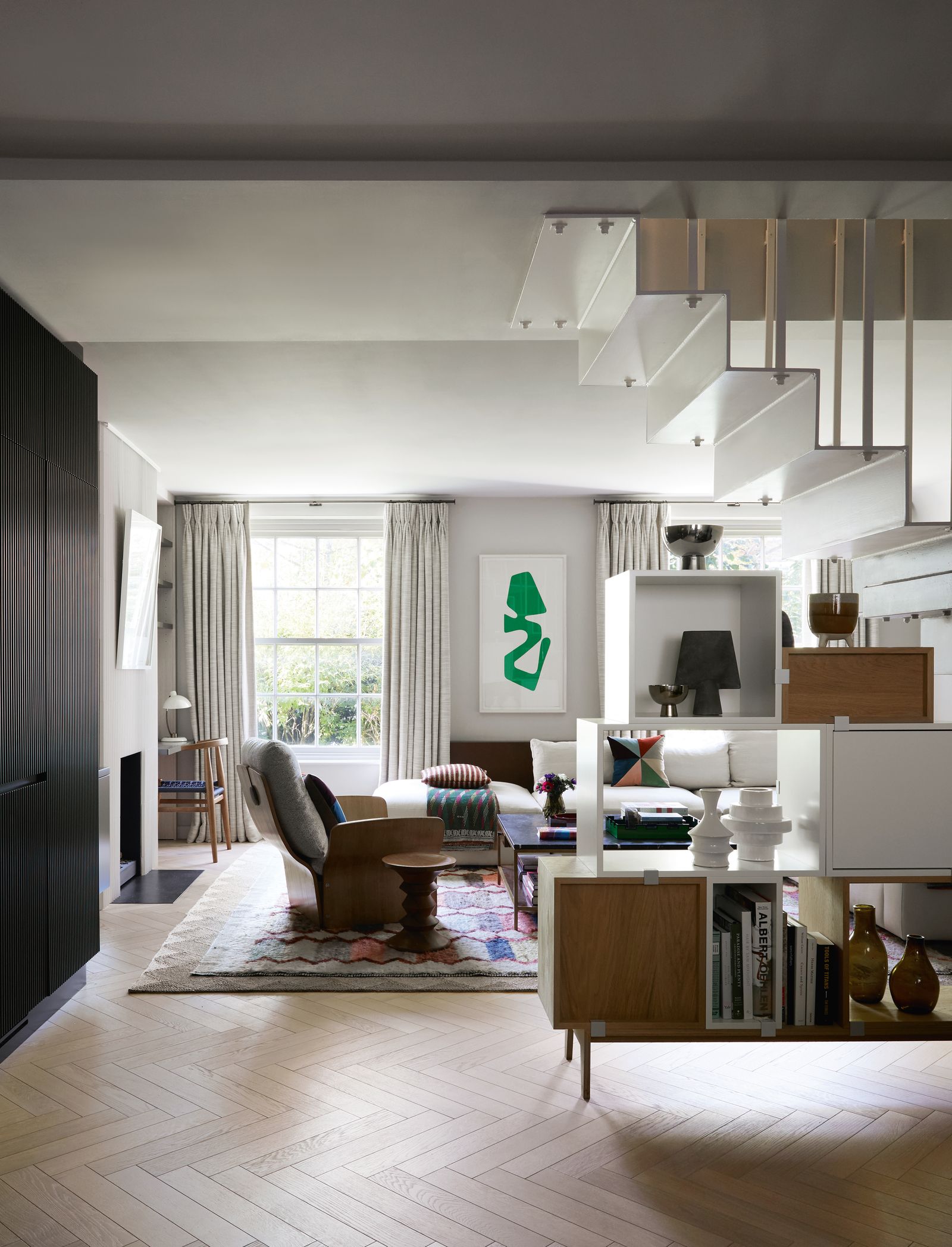 A stacked storage system by Muuto elegantly separates the sitting area from the kitchen and echoes the lines of the...