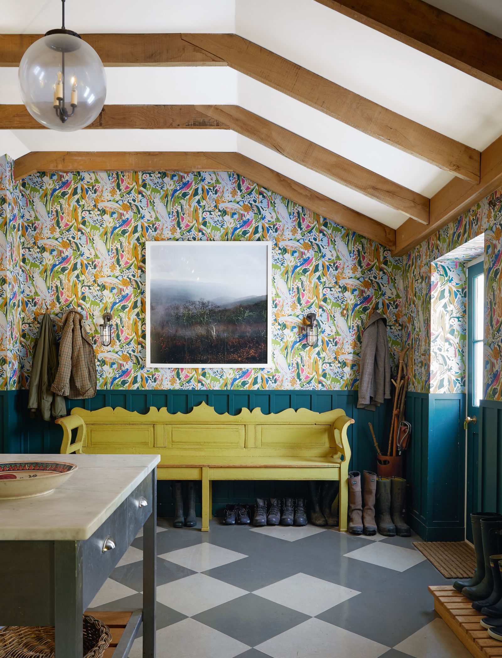 Pierre Freys ‘Le Chant de Tidore wallpaper and panelling in a custom green paint set off the yellow bench in the boot room.