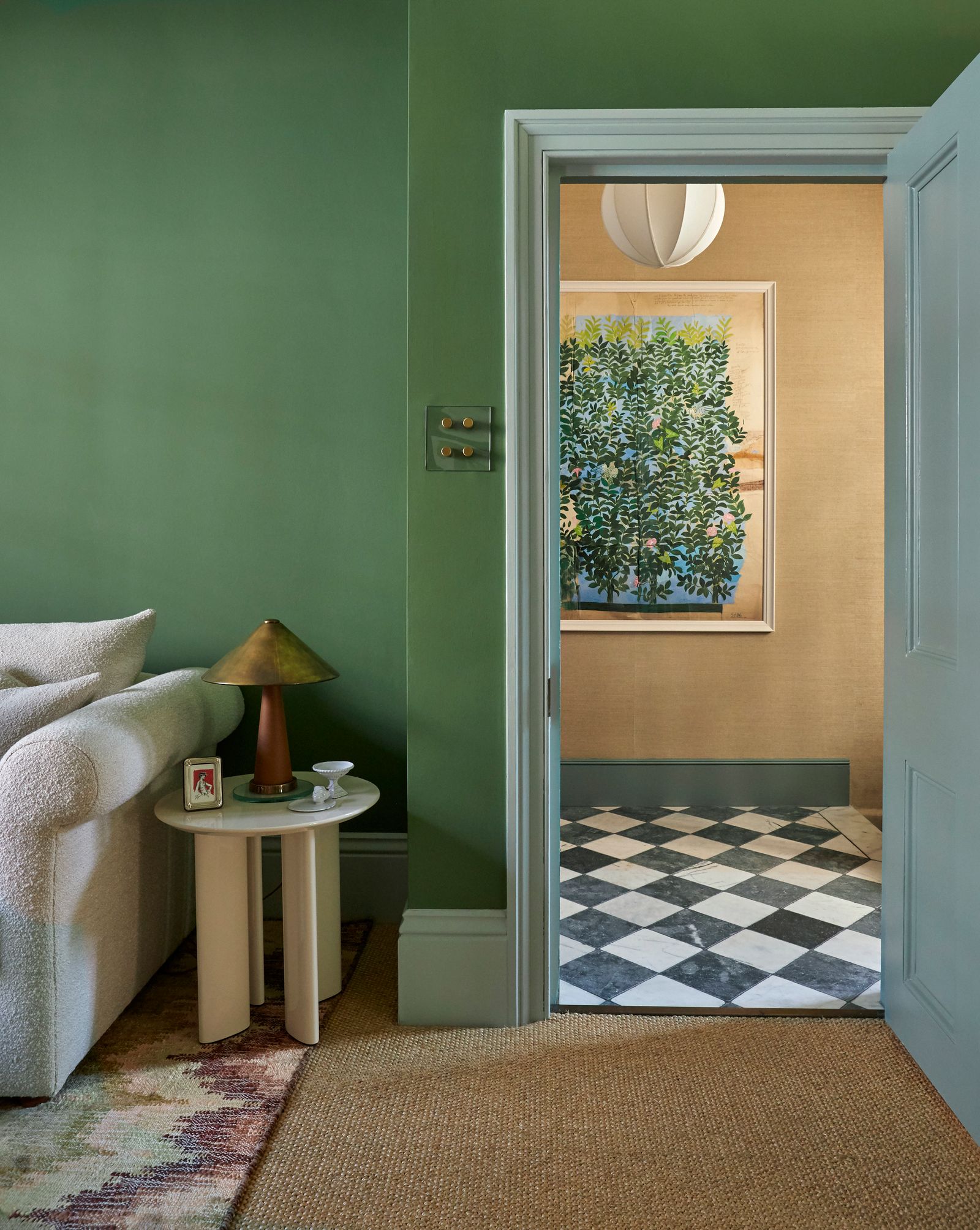 A textile print by Paule Marrot peeks through from the hallway. The walls are painted in Little Greene's ‘Apple Smiles...