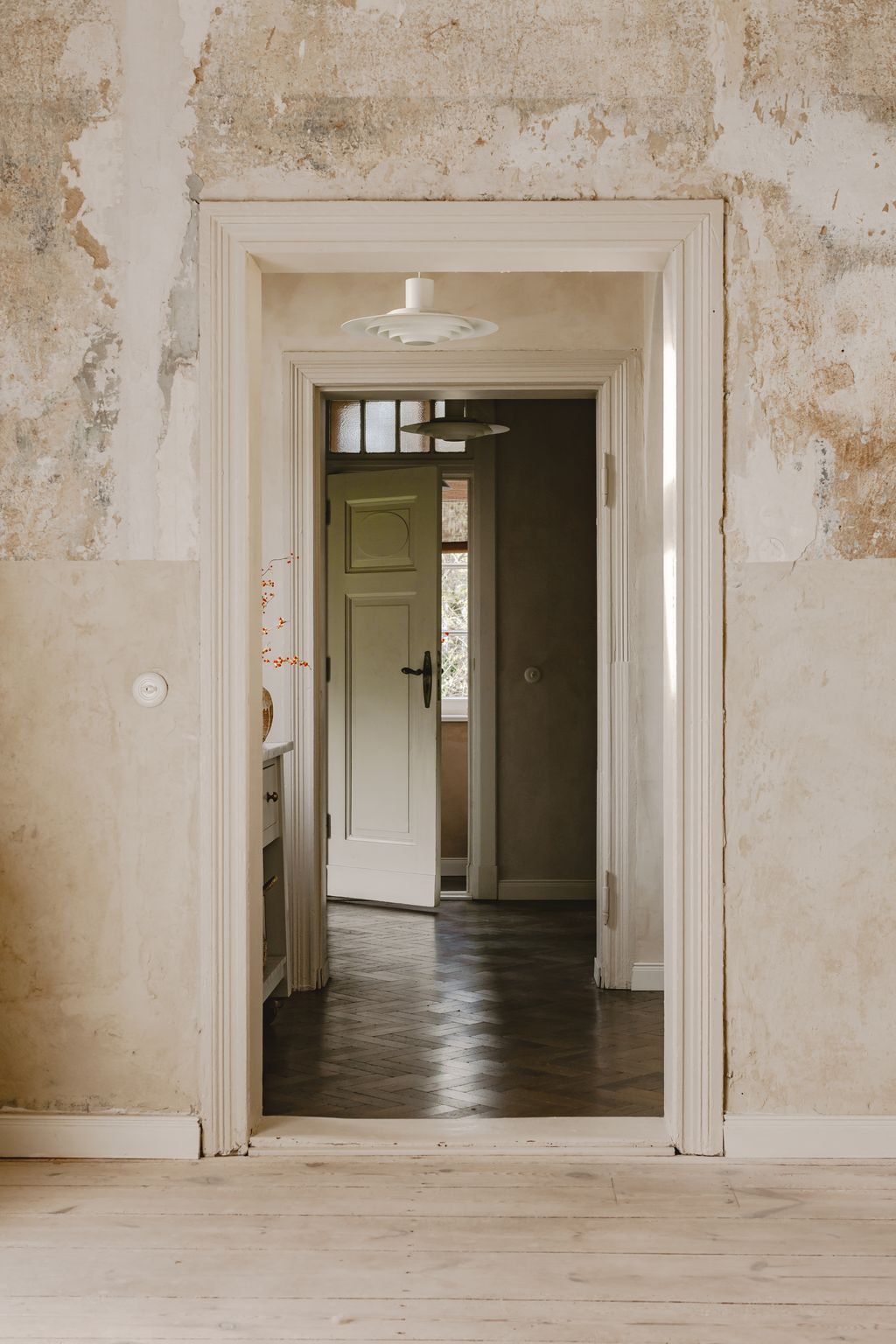 Raw unfinished walls frame a view to the door to the terrace.
