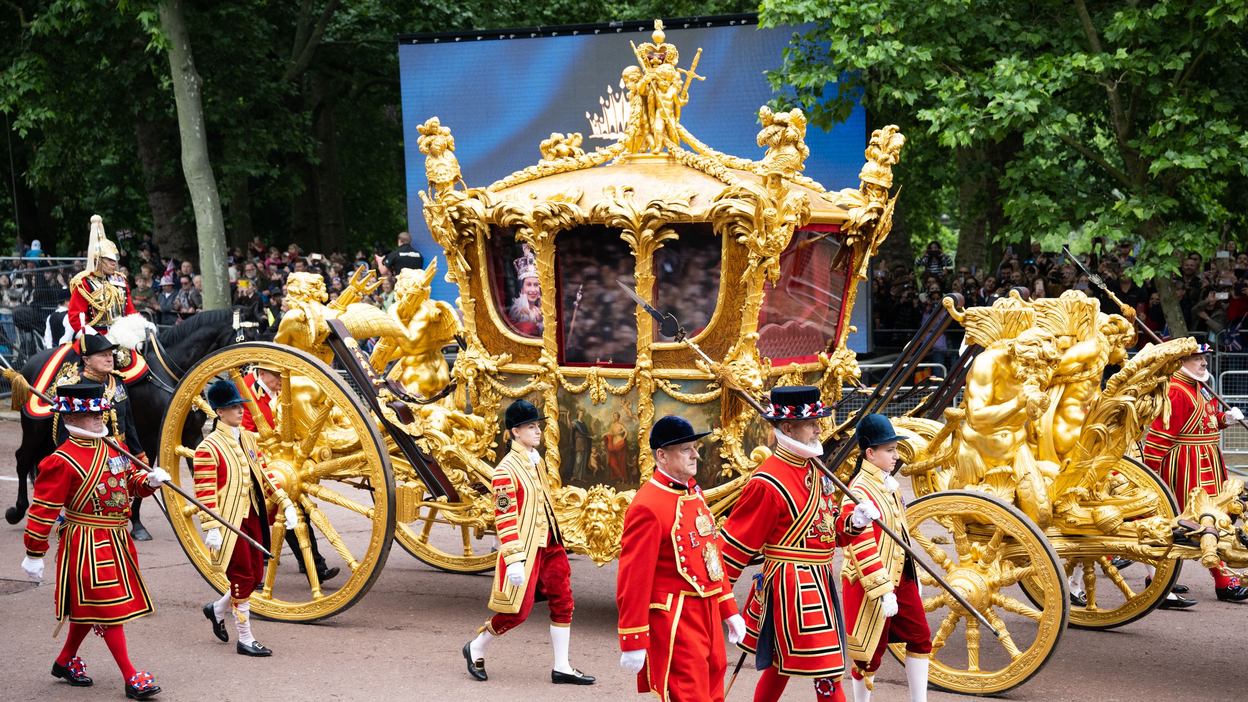 The Gold State Carriage in the procession to mark Queen Elizabeth II's Platinum Jubilee in 2022 with a hologram of Her...