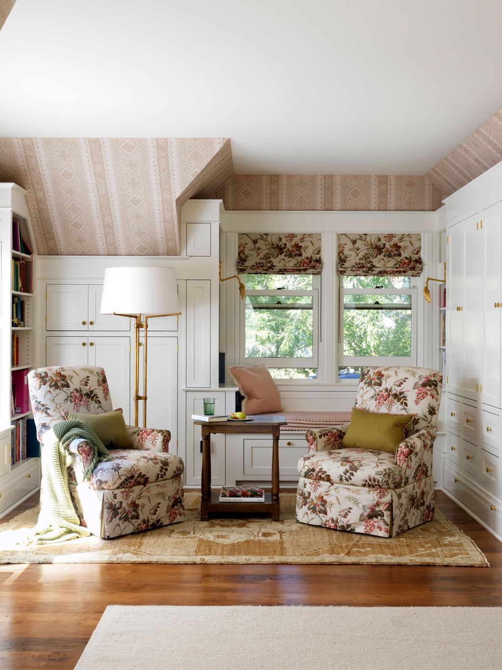 The reading nook in the primary bedroom is comprised of two armchairs bynbspTravis Company. The fabric for the Roman...