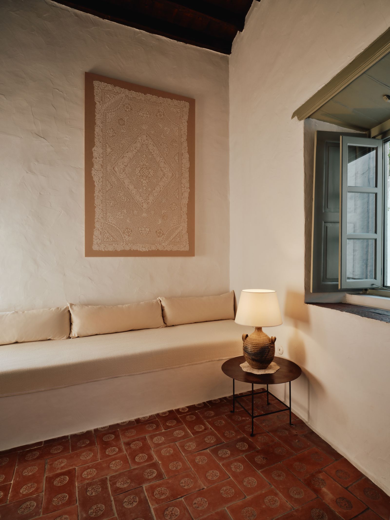 In the Fireplace Room at Pagostas a linenmounted lace tablecloth is displayed on the wall.
