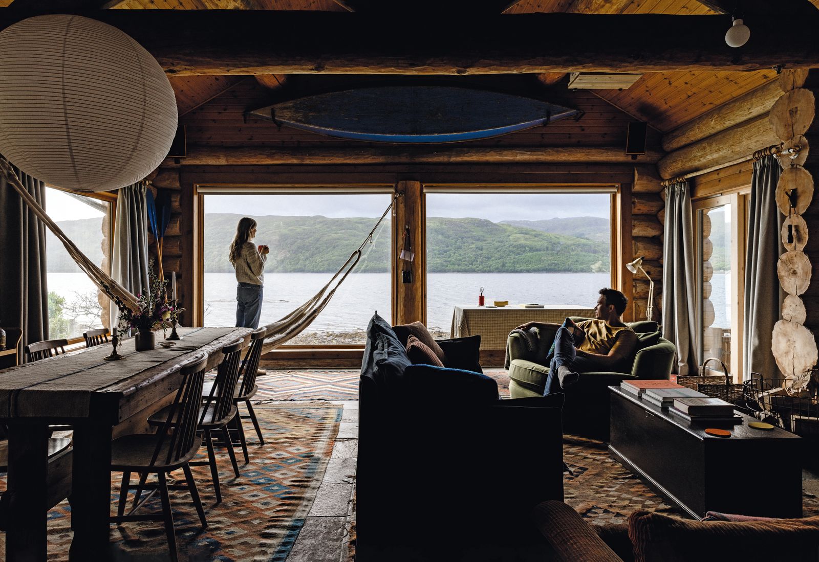 In the main living space secondhand furniture including a vintage Heals loveseat is mixed with a few contemporary...