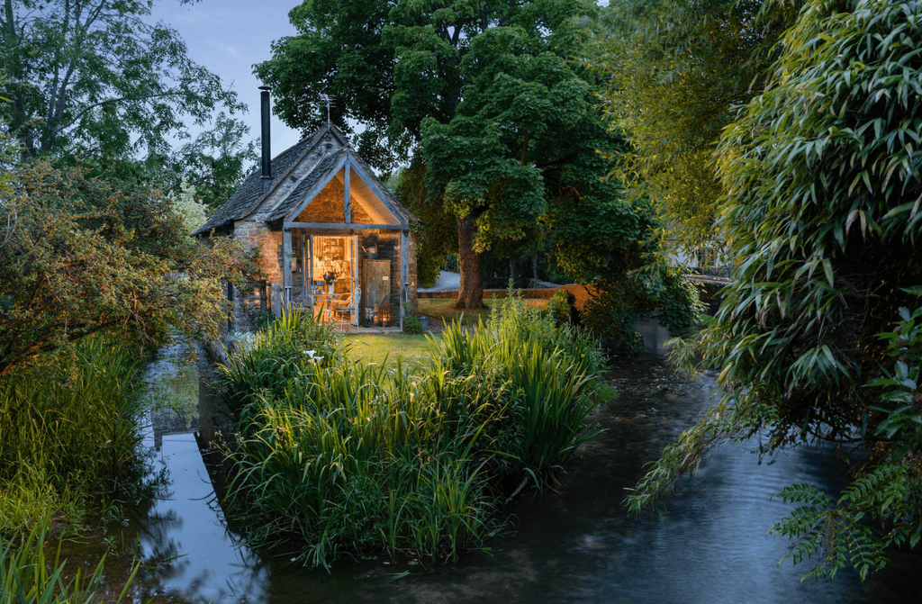Built on a small grassy island in the middle of a babbling brook only accessed by a humpback bridge sits this delightful...
