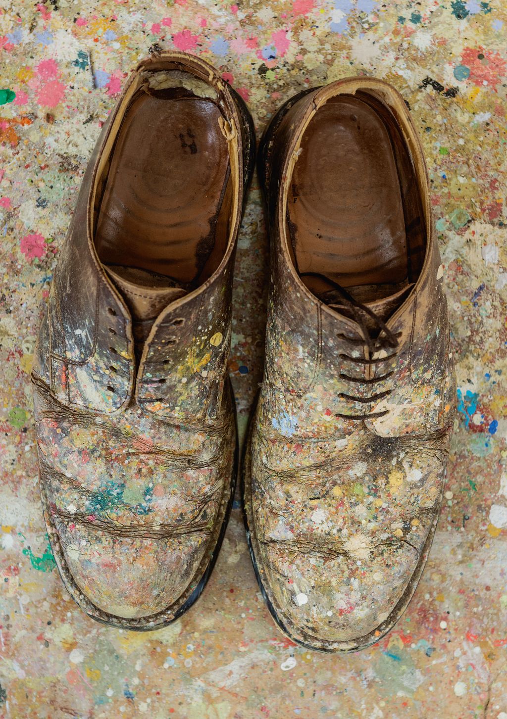 The artists shoes are splattered from years of painting