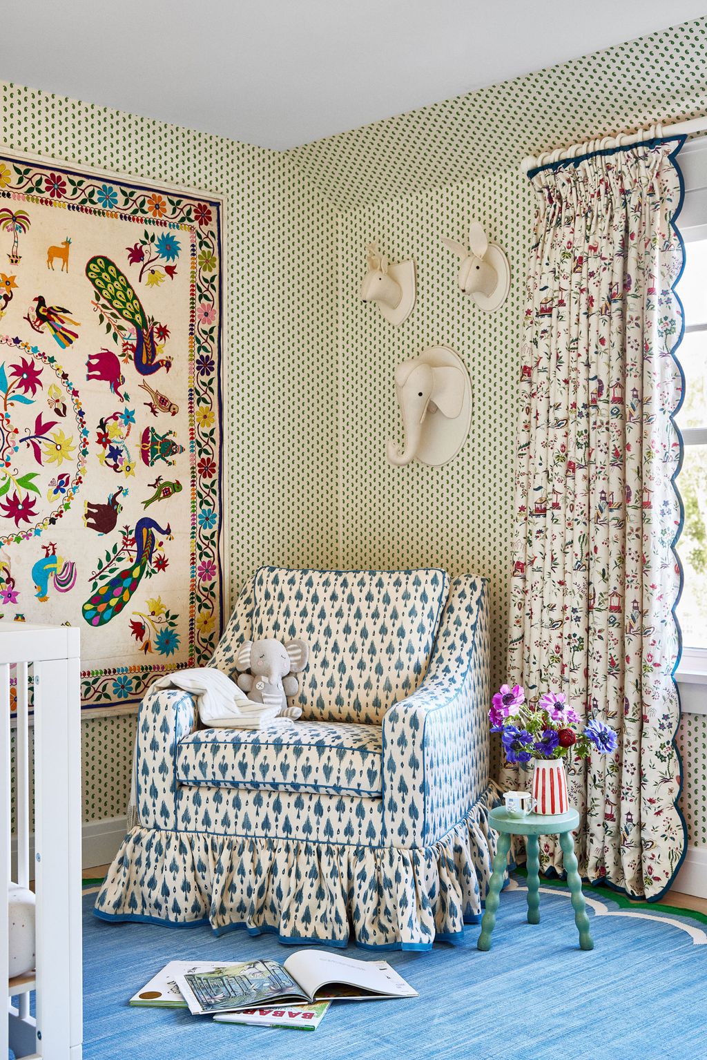The nursery is papered in Howe at 36 Bourne Street's ‘Mr Men pattern with curtains in Namay Samay's ‘PasseTemps. The...