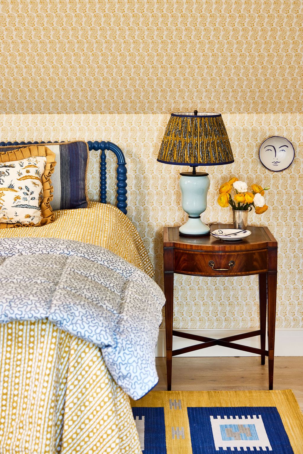 The bed has an eiderdown in Nine Muses Candence. A lamp from Vaughan stands on the bedside table.