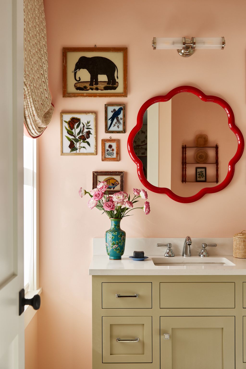 The bathroom has a mirror by Balineum set against walls in Sherwin Williams' ‘Blushing and joinery in ‘Grassland....